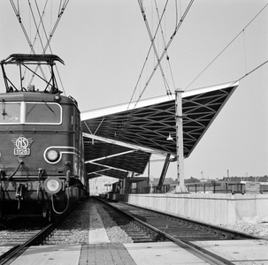 854529 Gezicht op het in aanbouw zijnde nieuwe N.S.-station Tilburg te Tilburg, met links de electrische locomotief nr. ...